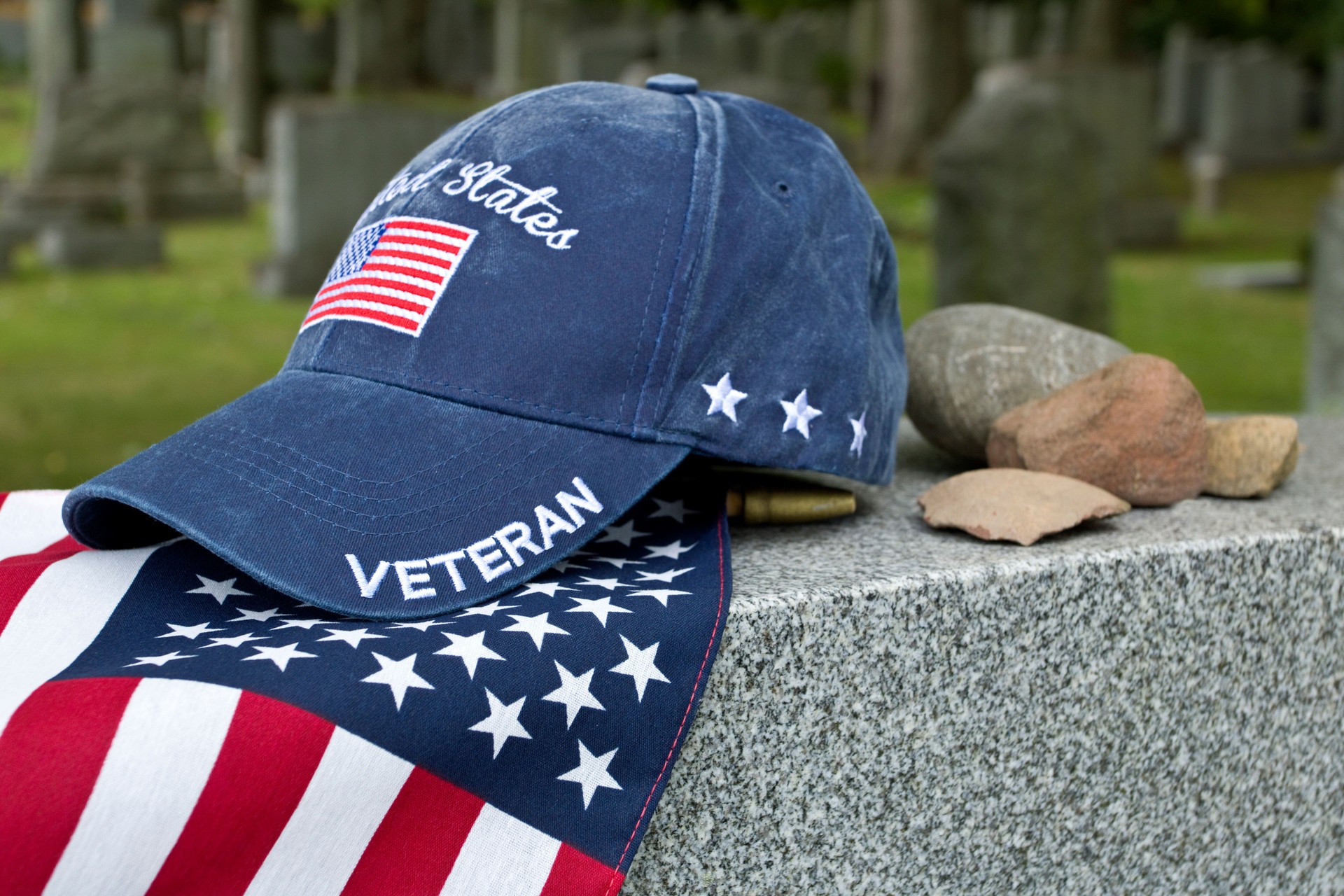 American Veterans cap on flag and grave marker in Jewish cemetery